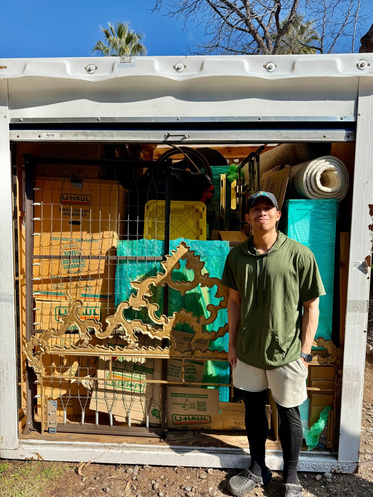 Outdoor storage container filled with U-Haul boxes, furniture, and various household items.